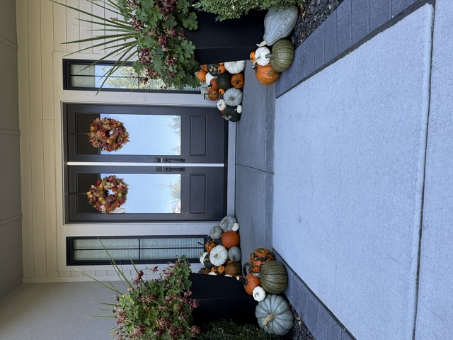 Porch at dusk with a bench, lanterns, and a lighted garland